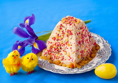 Easter cake of cheese (cheese pasha)  next to the iris and Easter egg on a blue background