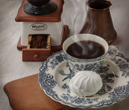 Marshmallow on vintage plate  with a cup of hot coffeeの写真素材
