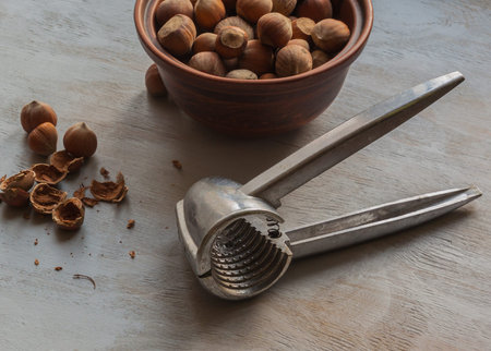 Nutcracker tool and hazelnuts on a wooden table