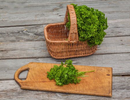 Basket with fresh parsley on kitchen tableの写真素材