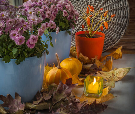 Pumpkin and chrysanthemum on the box next to  candle before the holidayの写真素材