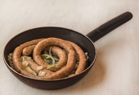 Hot fried with onion sausage in a frying panの写真素材