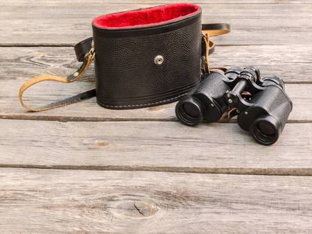 Binocular and the case on wooden table.の写真素材