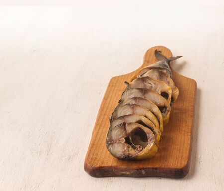 Mackerel smoked chopped to pieces on a cutting board  on the kitchen tableの写真素材