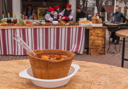 A plate of bread and soup on the background of showcases with a meal on a holiday Shrovetide.の写真素材