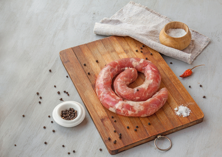 Ring of raw sausage on a cutting board with pepper, and garlic. Ukrainian folk cuisineの写真素材