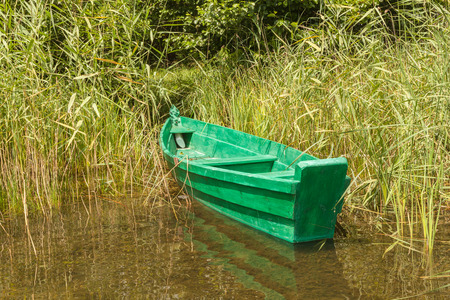 Green boat in the reeds at Lake Svitiaz (Svityaz, Shatsky National Natural Park, Ukraine).の写真素材