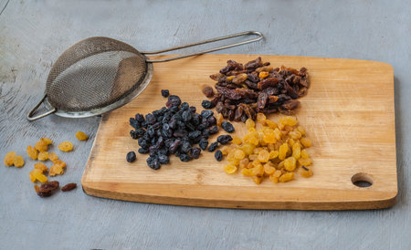 Three types of raisins on a cutting board