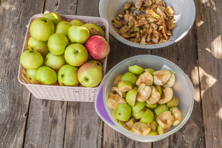 Cut into slices of apples in a bowl for jam on the wooden table, flat layの写真素材
