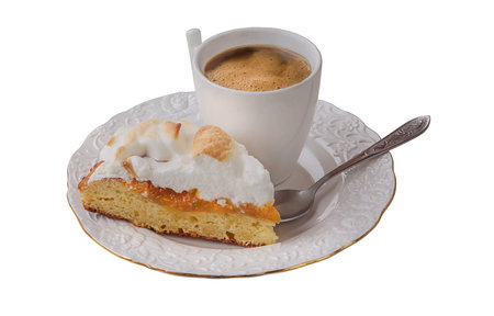 Piece of homemade cake with filled quince jam and meringue and cup of coffee on a white background isolatedの写真素材