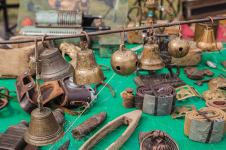 Flea market at Andreevsky Uzvoz in Kyiv, selling old household items for collection. Antique bells, hand bells, jingle bells at a flea marketの写真素材