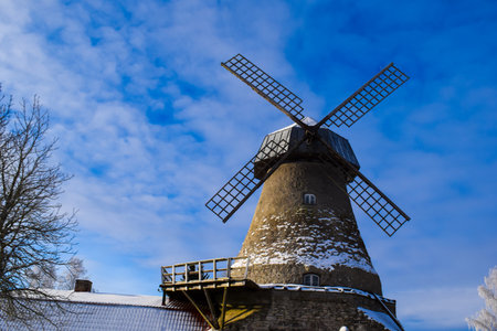 Historic Stone Windmill in Winter under Blue Skyの写真素材
