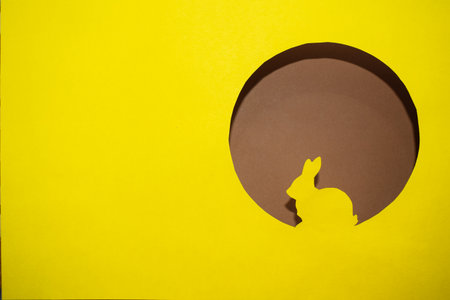 Yellow silhouette of Easter bunny in round windowの写真素材