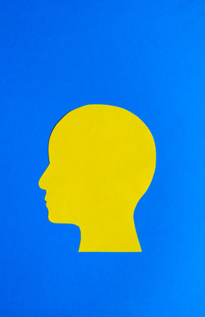 Yellow Human Head Silhouette on Blue Backgroundの写真素材