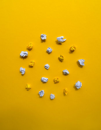 Crumpled Paper Balls on Yellow Backgroundの写真素材