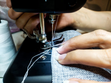 Sewing process with sewing machine, closeup of female hands