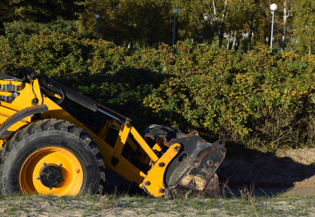 Yellow excavator on a construction site in the autumn