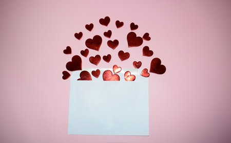 Envelope with red hearts on pink background. Valentine's day concept.の写真素材