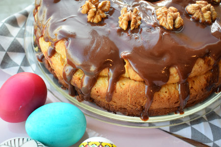 Easter cake with chocolate glaze and walnuts on a glass plate