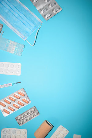 Medical mask and pills on a blue background. Top view with copy space.の写真素材