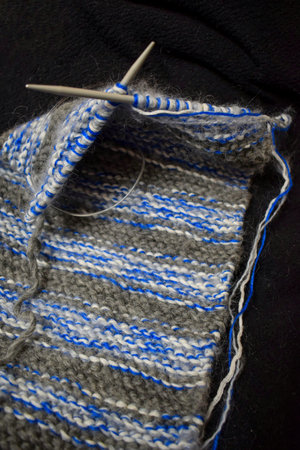 Knitting wool with needle and thread on a black background close up