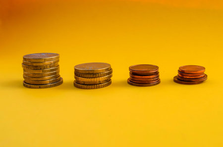 Stacks of coins on a yellow background. Business and finance concept.