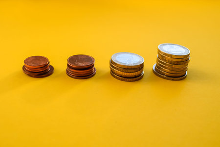 Stack of coins on yellow background, business and finance concept idea.