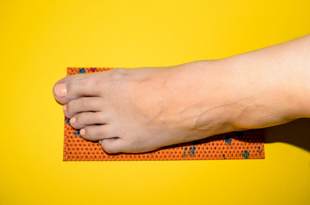 Close up of woman's foot on yellow background