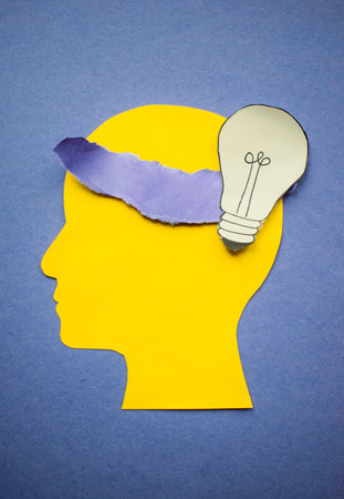 Creative idea concept with paper human head and lightbulb on blue background
