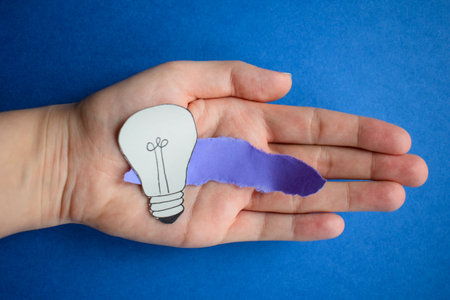 Creative idea concept. Lightbulb in hand on blue background