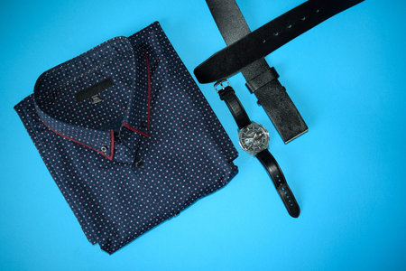Men's shirt and accessories on a blue background. Toned.