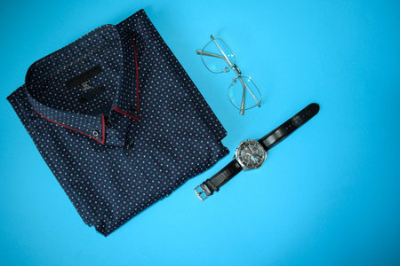 Men's shirt and watch on a blue background. Men's clothing.