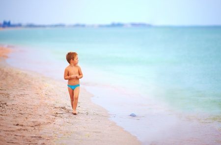 cute kid boy looking into the distance, sea beachの写真素材