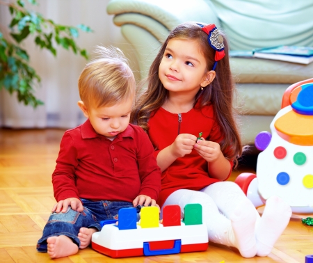 cute babies playing toys at homeの写真素材