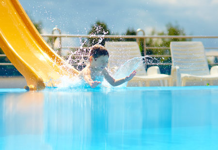 cute boy kid having fun on water slide