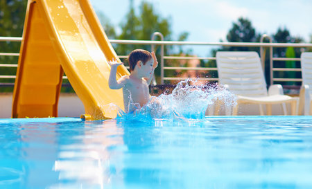 cute boy kid having fun on water slideの写真素材