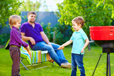 happy kids fighting with kitchen items on picnic