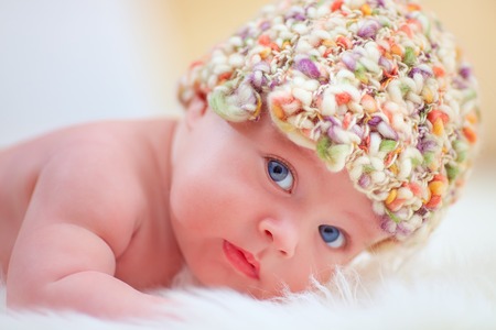portrait of cute little baby in colorful hatの写真素材
