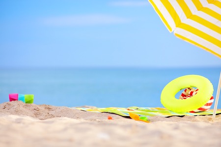 colorful beach items on sand near the seaの写真素材