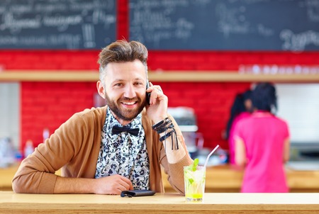 man talking the mobile phone in cafeの写真素材