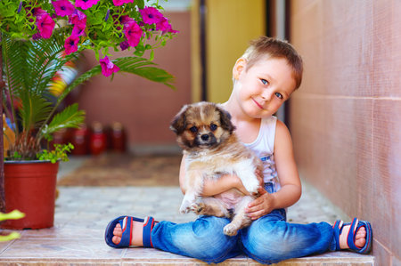young boy hugging little puppyの写真素材
