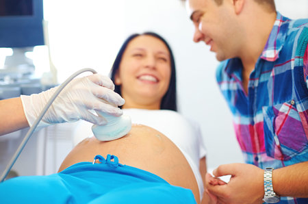 happy pregnant couple on ultrasound diagnostic