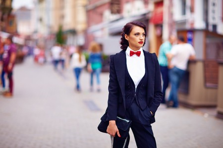 beautiful elegant woman posing on crowded city streetの写真素材