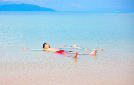 father and son enjoying life, relaxing in water edgeの写真素材