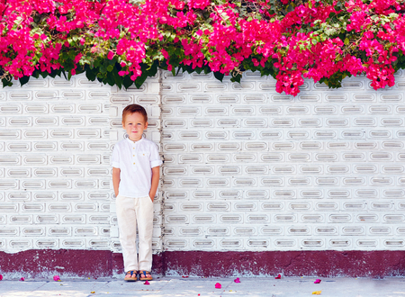 cute boy kid standing near blooming wallの写真素材