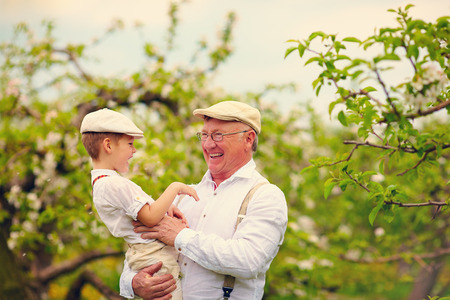 Grandfather with grandson having fun in spring gardenの写真素材