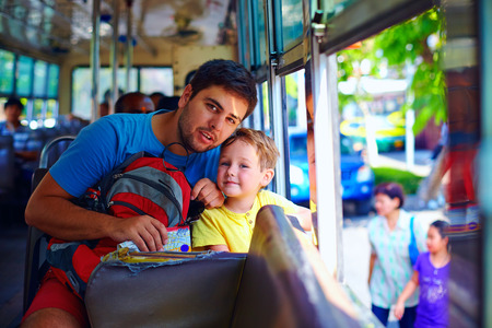 father and son traveling in public bus through asian cityの写真素材