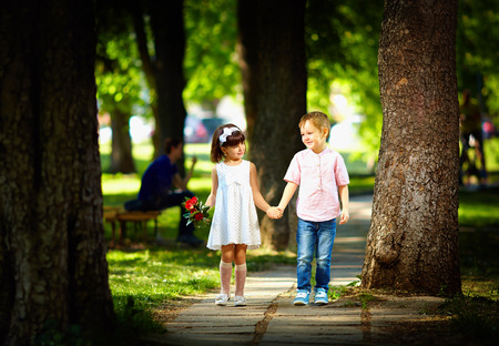cute kid walking together in summer parkの写真素材