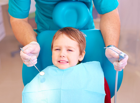 little kid patient afraid of dentist while visiting dental clinicの写真素材