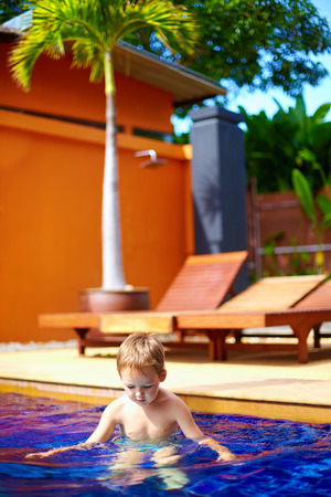 cute kid boy swimming in hotel poolの写真素材